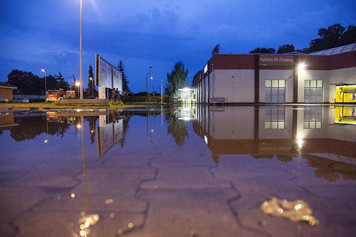 Podtopiony fragment parku i woda wokół marketu