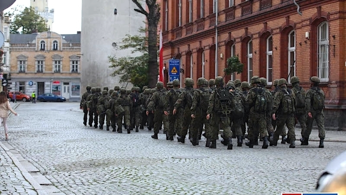 Przez miasto przemaszerują żołnierze.