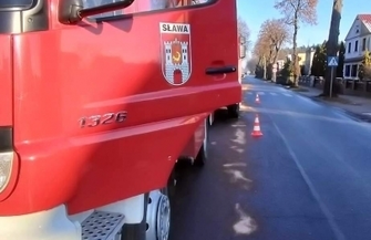 Kierowca forda wpadł w płot i znak drogowy.