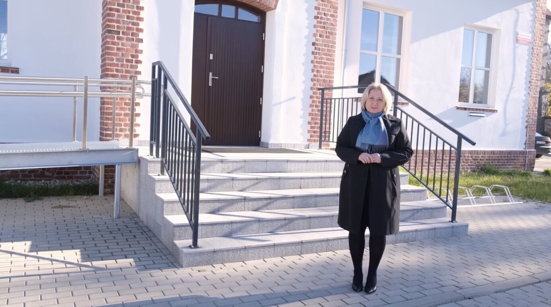Burmistrz Jolanta Wielgus przed wejściem do sali wiejskiej w Wyszanowie